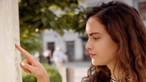 Woman-checking-schedule-in-the-city