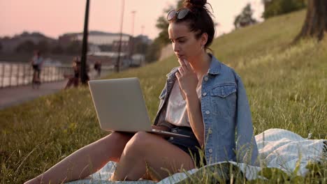 Young-woman-using-a-laptop-outdoors