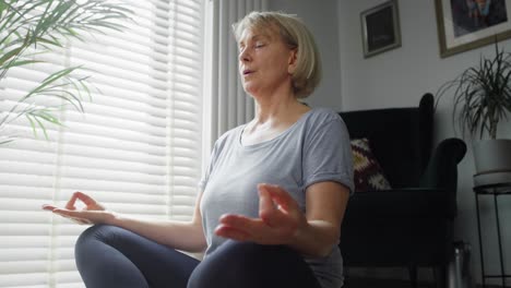 Unteransicht-Einer-älteren-Frau,-Die-Zu-Hause-Meditiert
