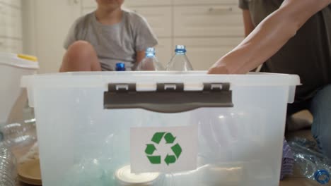 Tracking-Video-Eines-Mädchens,-Das-Zu-Hause-Recyclingmaterial-Trennt.