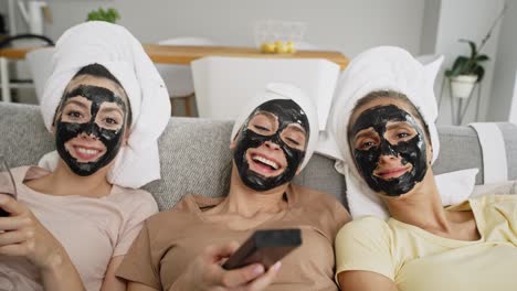 Video-of-three-friends-with-carbon-facial-mask-watching-TV