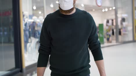 Tilt-up-video-of-man-in-shopping-mall-during-pandemic