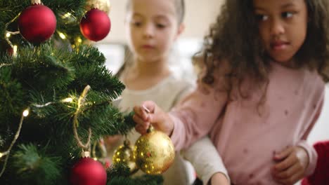 Handheld-Ansicht-Von-Zwei-Kleinen-Mädchen,-Die-Den-Weihnachtsbaum-Schmücken