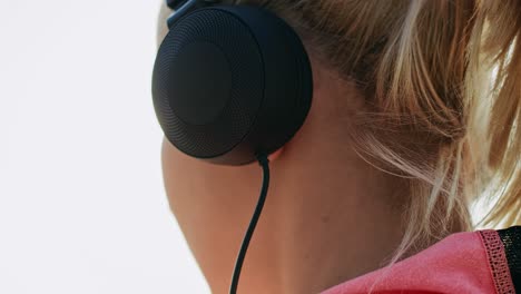 Handheld-Ansicht-Einer-Läuferin-Mit-Kopfhörern,-Die-Musik-Hört