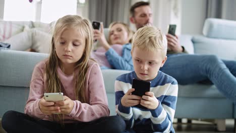 Vista-Portátil-De-Niños-Usando-Teléfonos-Inteligentes