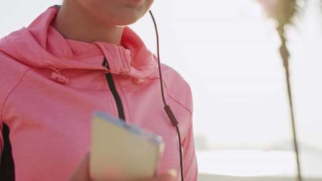 Handheld-view-of-woman-choosing-perfect-playlist-for-morning-running