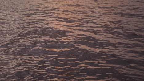 Ruhige-Sonnenuntergangsreflexionen-Abstrakter-Muster-Auf-Einer-Tropischen-Wasseroberfläche-Am-Abend