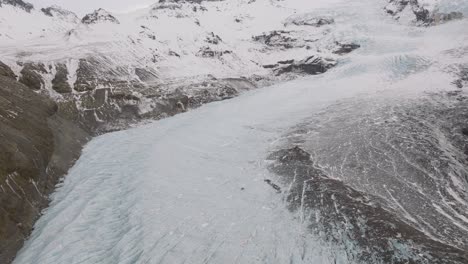 Aerial-landscape-view-over-people-hiking-on-the-ice-surface-of-Virkisjokull-glacier,-Iceland