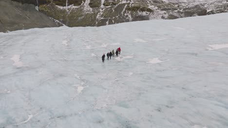 Aerial-view-of-people-hiking-on-the-ice-surface-of-Virkisjokull-glacier,-Iceland