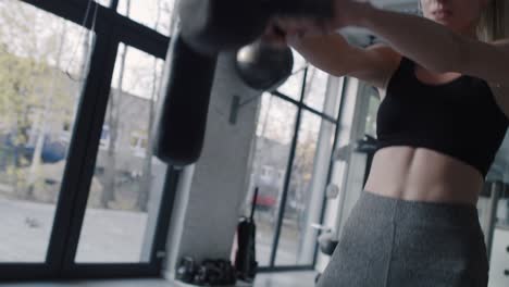 Handheld-view-of-woman-during-hard-workout-at-gym