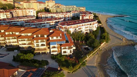 Aerial-view-rising-above-Meneda-Privilege-Fort-Seafront-Beach-Studio-Hotel-resort-in-Elenite,-Bulgaria