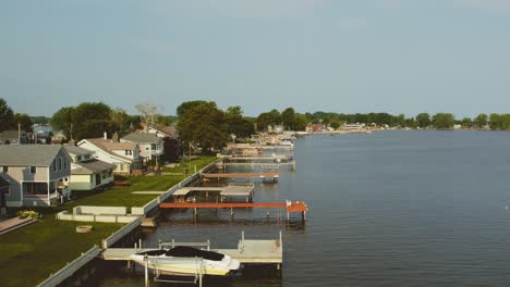 Disparo-De-Un-Dron-Flotando-Sobre-Las-Casas-De-Playa-Y-Los-Muelles-Para-Barcos-En-Sodus-Point,-Un-Lugar-De-Vacaciones-En-Nueva-York-En-La-Punta-De-La-Tierra-A-Orillas-Del-Lago-Ontario.