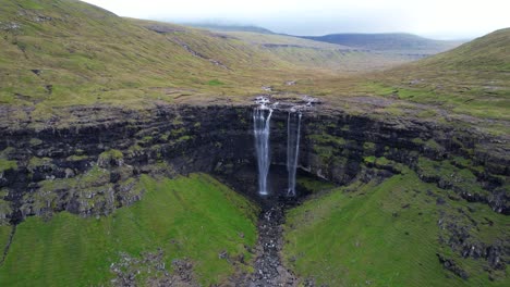 Aerial-backward-reveals-the-majestic-Fossa-waterfall-and-its-environment,-Faroe-Islands