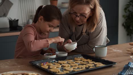 Kaukasisches-Mädchen,-Das-Mit-Großmutter-Selbstgemachte-Kekse-Dekoriert