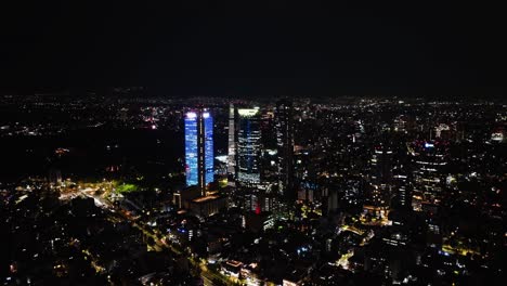 Aerial-view-approaching-the-illuminated-Reforma-skyscrapers-in-downtown-of-CDMX