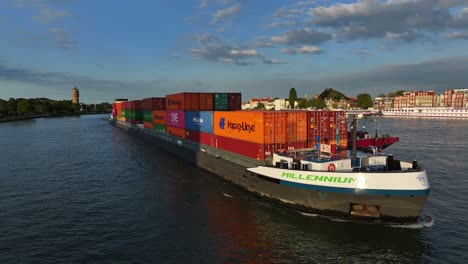 Under-beautiful-blue-sky-the-Cargo-ship-the-Millenium-sails-past-Dordrecht,-aerial