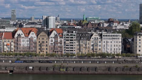 Aerial-panoramic-cityscape-of-Dusseldorf,-Rhine-river-waterfront-lined-by-buildings
