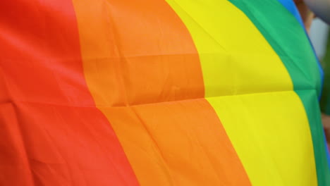 Niñas-Tratando-De-Desplegar-Una-Bandera-Colorida-Con-Colores-Lgbt---Primer-Plano-De-Los-Detalles-Materiales-Y-Las-Palmas