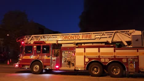 El-Camión-De-Bomberos-De-Toronto-Enciende-Sus-Luces-Y-Se-Aleja-Rápidamente-De-La-Escena-Del-Edificio-Lleno-De-Humo-Por-La-Carretera