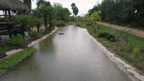 A-pond-during-the-rains-surrounded-by-green-vegetation-mainly-consisting-of-palm-trees