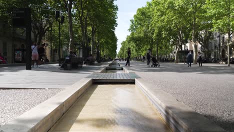 Canal-De-Agua-En-La-Plaza-Jean-Jaurès-En-Nîmes-Con-Transeúntes-Y-Turistas