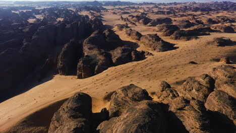 Aerial-tilt-shot-rotating-over-desert-rocks-and-cliffs,-golden-hour-in-Arabia