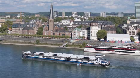 Cargo-ship-carrying-brand-new-white-vans-on-Rhine-river-in-Dusseldorf-city