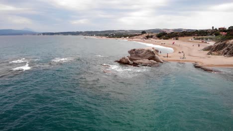 Drohnenvideo,-Das-über-Felsformationen-Fliegt,-Meereswellen,-Die-Menschen-Beim-Schwimmen-Im-Sommer-Zerschmettern