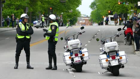 Toma-En-Mano-De-Agentes-De-Policía-De-Pie-Bloqueando-La-Carretera-Con-Sus-Bicicletas-En-La-Cumbre-Del-G7.