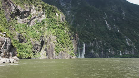 Breathtaking-point-of-view-from-a-boat,-gazing-at-distant-waterfalls-in-Milford-Sound