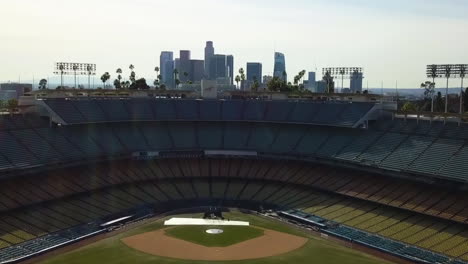 Aerial-view-rising-over-the-Dodgers-stadium,-toward-the-skyline-of-Los-Angeles,-USA