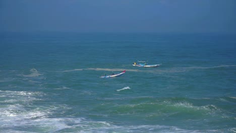 Small-fisherman-boats-swinging-on-ocean-waves-in-Indonesia,-aerial-view