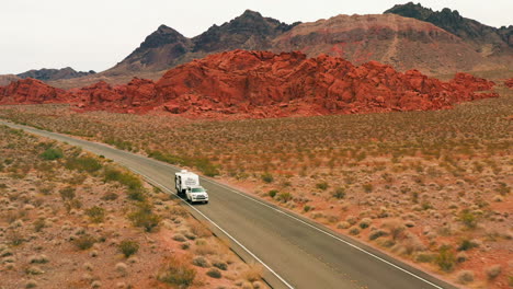 Aerial-pull-back-shot-in-front-a-truck-with-trailer-in-the-deserts-of-Nevada,-USA