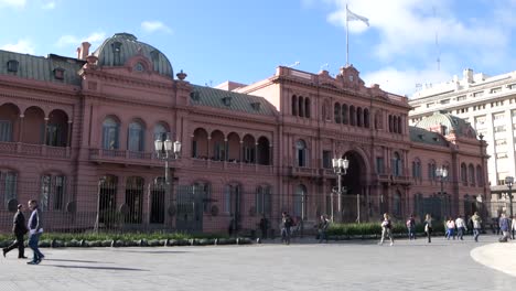 Wide-view-of-pedestrians-passing-by-the-Casa-Rosada,-Argentina's-Presidential-Palace