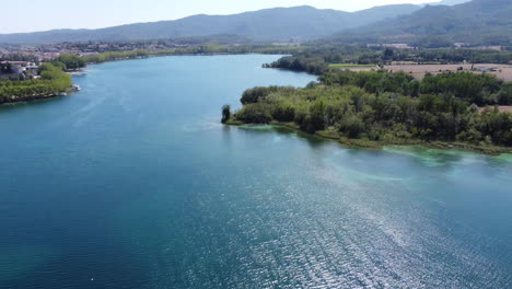 Spinning-drone-footage-aerial-view-of-a-famous-beautiful-natural-lake-with-blue-and-turquoise-water-in-Catalonia-Spain