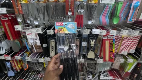 POV-shot,-customer-buying-stainless-steel-spoons-at-shopping-mall