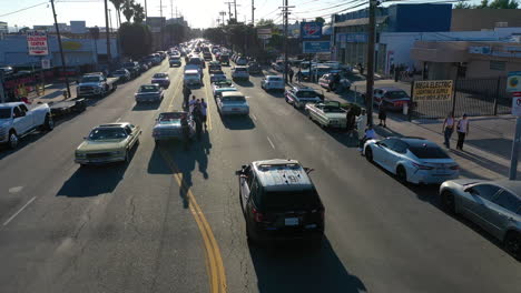 Vista-Aérea-Siguiendo-A-La-Policía-Observando-A-Los-Lowriders-En-Las-Calles-De-Los-Ángeles,-EE.UU.