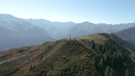 Filmische-Drohnenantenne-über-Dem-Berggipfel-Mit-Kreuzneigung-Nach-Unten,-Fantastische-Aussicht-Auf-Den-Gipfel-Mit-Schönem-Hintergrund