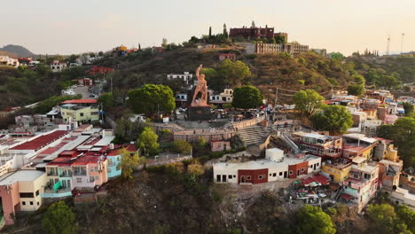 Vista-Aérea-Alrededor-De-La-Estatua-De-El-Pipila,-Hora-Dorada-En-La-Ciudad-De-Guanajuato,-México