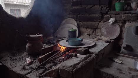 Zeitlupenaufnahme-Eines-Holzfeuers,-Das-Einen-Keramiktopf-In-Einem-Haus-In-Mexiko-Erhitzt