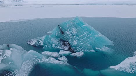 Aerial-landscape-view-of-icebergs-in-the-glacial-water-of-Jokulsarlón-lake,-in-Iceland,-during-winter