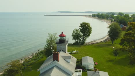 Toma-De-Drone-Retrocediendo-Para-Ver-Una-Hermosa-Imagen-De-Los-Faros-Y-El-Museo-En-Sodus-Point,-Lugar-De-Vacaciones-De-Nueva-York-En-La-Punta-De-La-Tierra-A-Orillas-Del-Lago-Ontario.