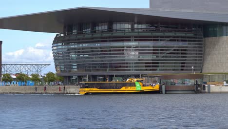 Copenhagen-Opera-building-with-people-and-yellow-water-taxi-in-front---Denmark