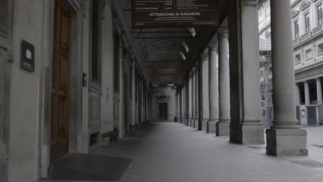 Walking-under-the-arches-of-Uffizi-Gallery,-an-art-museum-located-adjacent-to-the-Piazza-della-Signoria-in-the-Historic-Centre-of-Florence