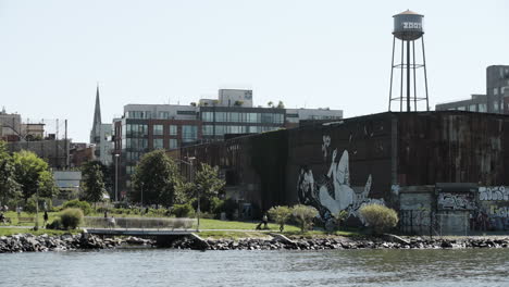 Families-Walking-Along-Brooklyn-Waterfront-on-Summer-Morning