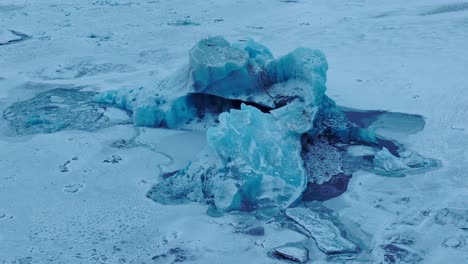 Vista-Aérea-Sobre-Los-Icebergs-En-La-Superficie-Congelada-Del-Lago-Jokulsarlón,-En-Islandia,-Al-Atardecer