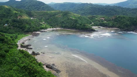 Picturesque-Beach-Surrounded-With-Lush-Green-Hills-In-Puraran,-Baras,-Catanduanes,-Philippines---aerial-shot