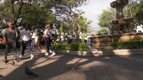 Los-Turistas-Deambulan-Y-Exploran-El-Parque-Central-De-Guatemala,-Las-Palomas-Caminan-En-El-Parque