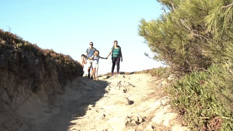 Parents-and-kids-walking-on-path-downhill-at-countryside