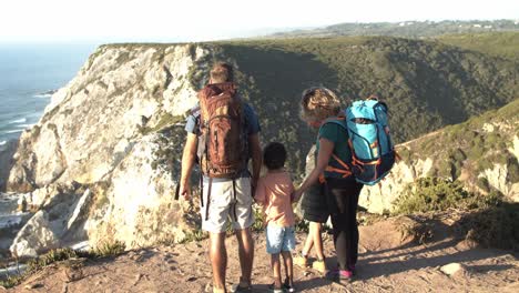 Couple-of-active-parents-with-camping-backpacks-and-two-kids
